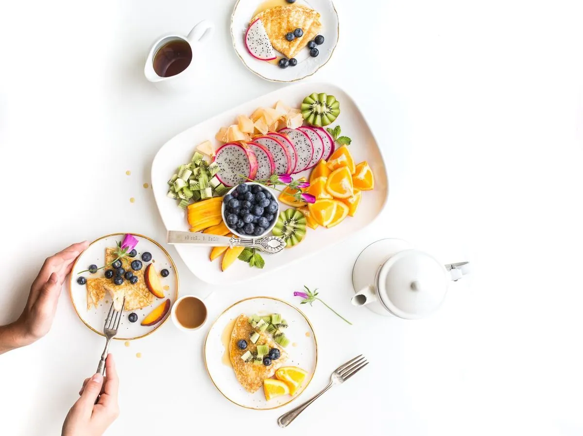 Pause gourmande : plateau de fruits frais, crêpes, café et thé